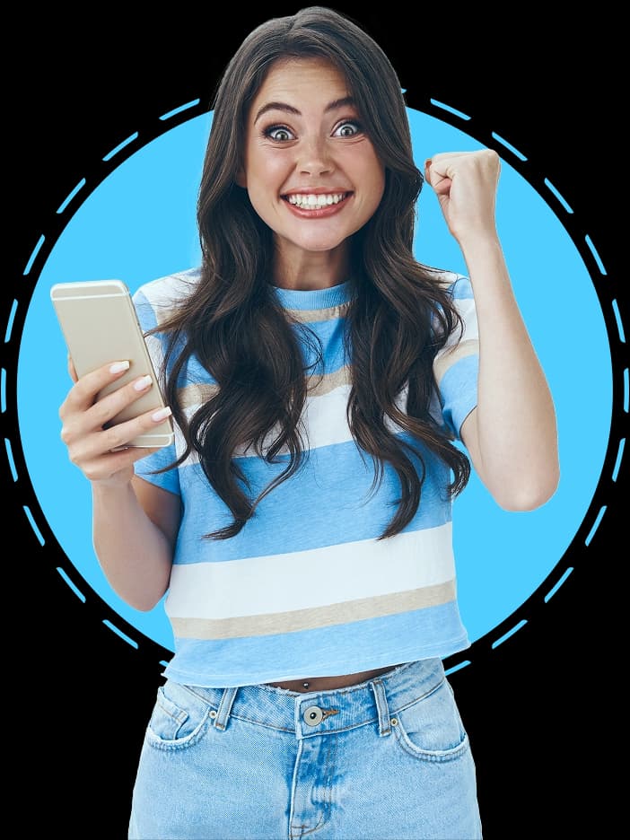 Mulher jovem sorridente segurando um smartphone e comemorando com o punho cerrado